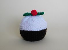 a crocheted white and black cupcake ornament with a red cherry on top