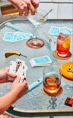 people playing cards at a table with drinks