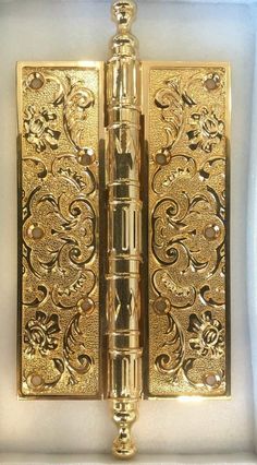 a gold lighter in a white box with floral designs on the front and back sides