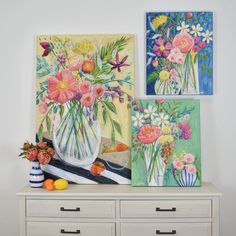 three paintings on a wall with flowers in vases