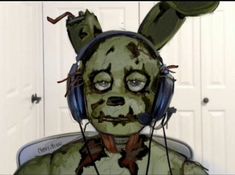 a person with headphones on wearing a green bunny costume