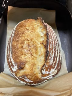 a loaf of bread sitting on top of a piece of wax paper in a pan