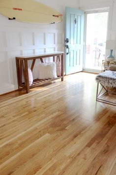 a living room filled with furniture and a surfboard on top of the door sill