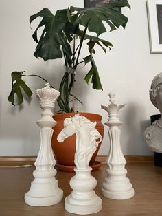 a potted plant sitting on top of a wooden table next to white chess pieces