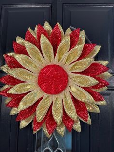 a red and gold wreath on a black door