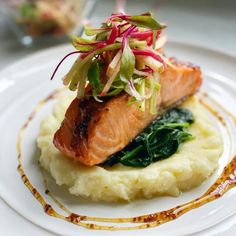 a white plate topped with mashed potatoes and salmon