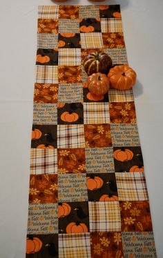 an orange pumpkin sitting on top of a table next to a checkered table runner