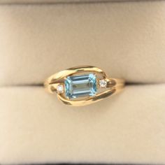 Handmade 18 Karat Solid Gold ring with natural emerald cut sky blue Aquamarine and two natural diamonds set on either side of the primary stone. What you get: - The ring  - A beautiful box for the ring Item Details: Primary stone: 7x5 mm Emerald Cut Natural Aquamarine from Brazil Metal: 18 Karat Solid Gold Diamond: 1.5mm Natural Diamond x 2, I Colour - VS1 Ring Size: US 7.5 and can be altered +/- 1 US Size Ring weight: 4.2 grams Please do note, this is a handcrafted ring with Gold, Diamond and A Yellow Gold Aquamarine Jewelry With Accent Stones, Rectangular Yellow Gold Topaz Ring, Emerald-cut Sapphire Birthstone Ring, Blue Emerald Cut Ring For Birthstone, Blue Emerald Cut Ring, Birthstone, Yellow Gold Rings With Rectangular Accent Stones, Emerald Cut Diamond Topaz Ring, Gold Aquamarine Diamond Ring, Emerald-cut Aquamarine Rings For Anniversary