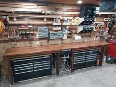 a workbench with lots of tools hanging on the wall and shelves above it