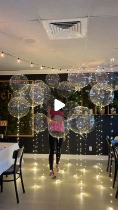 a woman is standing in front of some clear bubbles that are floating over her head