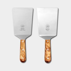 two large spatulas with wooden handles on each side