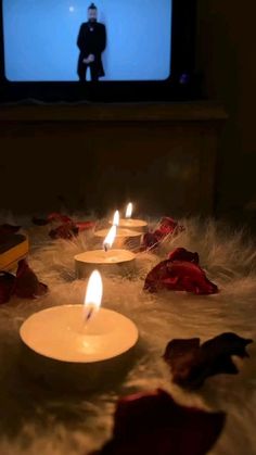 several candles are lit in front of a television