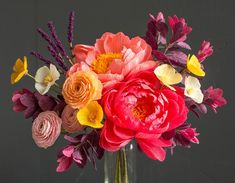 a vase filled with lots of different colored flowers