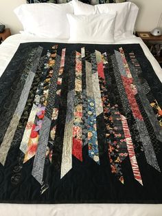 a bed with a black quilt on top of it