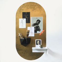 there is a gold and white wall with pictures on it, along with other items