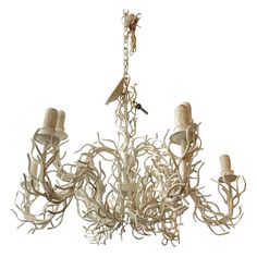 a chandelier made out of branches with hats on them and birds perched on top