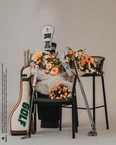 flowers are sitting on top of a chair next to a golf bag and two racquets