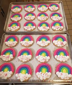 two trays filled with rainbow cookies on top of a table