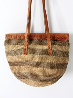 This is a woven sisal shoulder bag with leather top and accents. Warm hues of olive green and beige color the striped shopper. It closes with a belted leather strap, and long double straps carry the bag. It has an unlined interior. CONDITIONIn good condition with wear consistent with age and use. MEASUREMENTSWidth: 15" .. 38. 1 cmHeight: 9. 5" .. 24. 1 cmDepth: 9" .. 22. 9 cmStrap Drop: 15" .. 38. 1 cm62102 Hippie Boots, Vintage Clothing Online, Bag Shop, Free Bag, Leather Top, Beige Color, Vintage 70s, Purses And Handbags, Leather Shoulder Bag