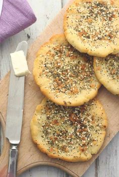 four crackers on a cutting board with butter and seasoning