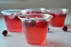 several plastic cups filled with cranberry juice