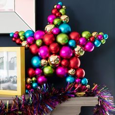 christmas decorations are displayed on the mantle in front of a framed photo and an ornament