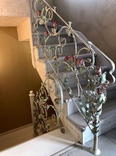 an iron stair railing with flowers on it