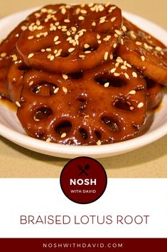 a white plate topped with lots of pretzels covered in brown sauce and sesame seeds