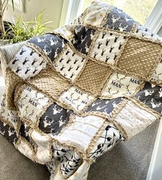 a blanket that is sitting on the floor next to a potted plant in front of a window