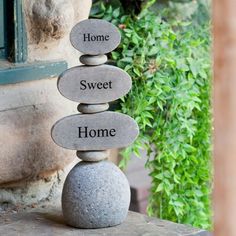 three stones stacked on top of each other with the words home, sweet and home written on them