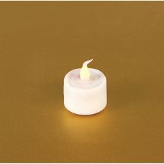 a small white candle on a brown surface