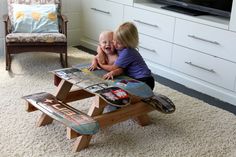 two children sitting at a table with skateboards on it in front of a tv