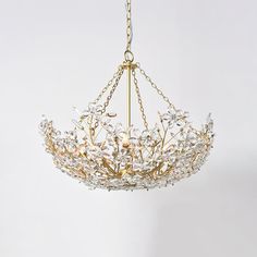 a gold chandelier hanging from a chain with crystal flowers and leaves on it