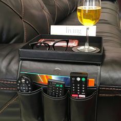 there is a remote control and glasses on top of a leather couch with a card holder in the pocket