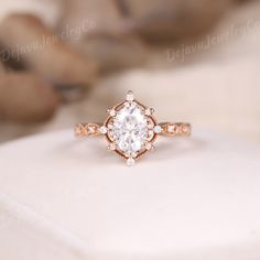 a close up view of a diamond ring on top of a white cloth with a dog in the background