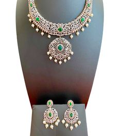 This stunning CZ American Diamond South Indian Haaram is a perfect addition to your collection. Featuring green stones and a medium size, it is ideal for both weddings and parties. It also makes a great gift for her. Elevate your Indian outfit, whether it's a silk saree or a gown, with this elegant piece. This jewellery set includes a necklace, matching earrings. Jewellery Care- Keep the jewellery dry, avoid contact with perfumes and water. Elegant Anniversary Jewelry Sets With Stone Work, Green Sparkling Stones Jewelry Sets For Wedding, Elegant Emerald Jewelry Sets With Stone Work, Dazzling Green Jewelry Set With Elegant Design, Elegant Green Jewelry With Stone Work, Green Bridal Necklace With Elegant Crystal Design, Green Crystal Bridal Necklace With Elegant Design, Green Emerald Bridal Necklace With Elegant Design, Elegant Green Crystal Bridal Necklace