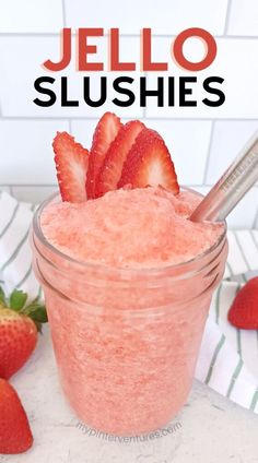 a jar filled with strawberry jello slushies on top of a counter next to strawberries