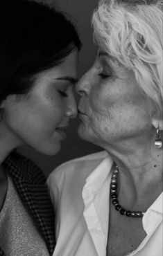 two women are kissing each other in black and white