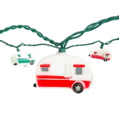 an rv ornament hanging from a green string with two cars attached to it