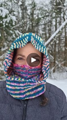 a woman wearing a multicolored knitted hat and neck scarf in the snow