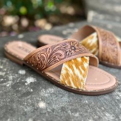 By Myra Handcrafted with exquisite attention to detail, these luxurious Mukluk sandals feature an intricate criss-cross pattern of leather and tan and white hair-on hide. Add a sophisticated edge to any ensemble with these elegant, yet edgy, slides on sandals. Rubber sole and cushioned foot bed. True to size, if between sizes, size up Western Style Open Toe Sandals For Spring, Summer Calf Hair Sandals, Traditional Hand Tooled Open Toe Sandals, Bohemian Hand Tooled Brown Sandals, Tooled Birkenstock Sandals, Hand Tooled Leather Slip-on Huaraches, Hand Tooled Brown Slip-on Sandals, Cross Patterns, Cross Straps