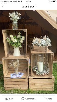 three wooden crates with vases and flowers in them sitting on the grass next to each other