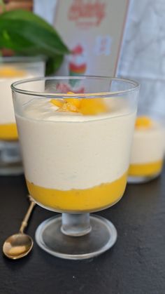 two desserts in small glass dishes with spoons on the table next to each other