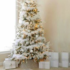 a white christmas tree with presents under it