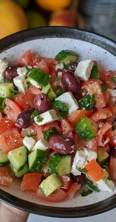 a bowl filled with cucumber, tomato and feta cheese