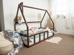 a child's room with a bed and stuffed animals on the floor in it