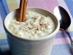 two cinnamon sticks sticking out of a cup of milk