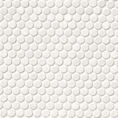 a white tile wall with circles on the bottom and one circle in the middle, as well