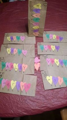 several pieces of paper with hearts on them sitting on top of a red cloth covered table