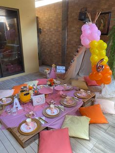 a table set up with balloons and plates